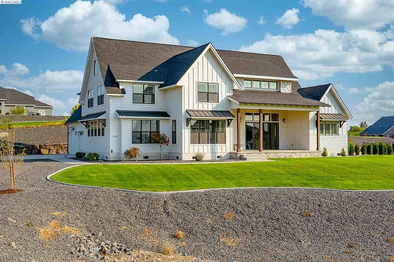 Kennewick, Washington Modern Farmhouse custom built for a family with a play loft, pool, garden, black windows, views from all rooms, built-in office, and barn doors on the pantry.